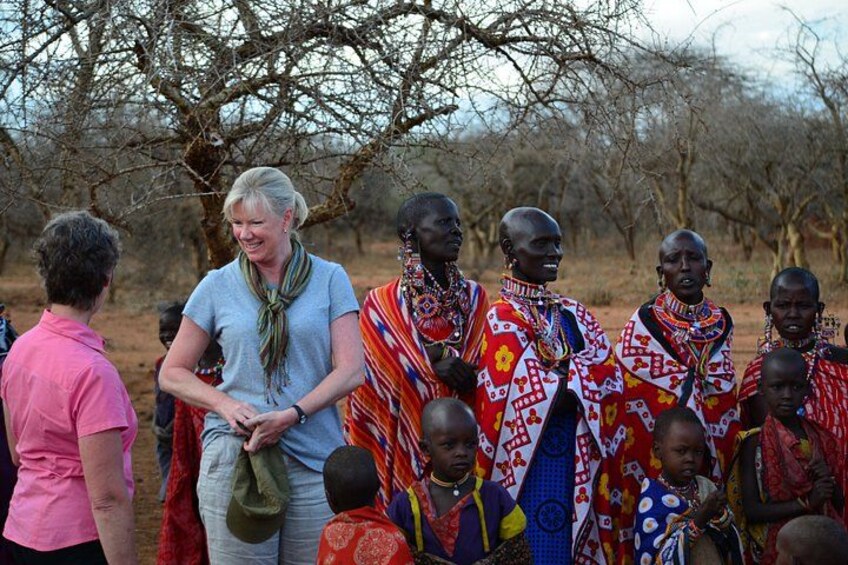 A group of people in traditional attire standing outdoors with trees in the background. 5