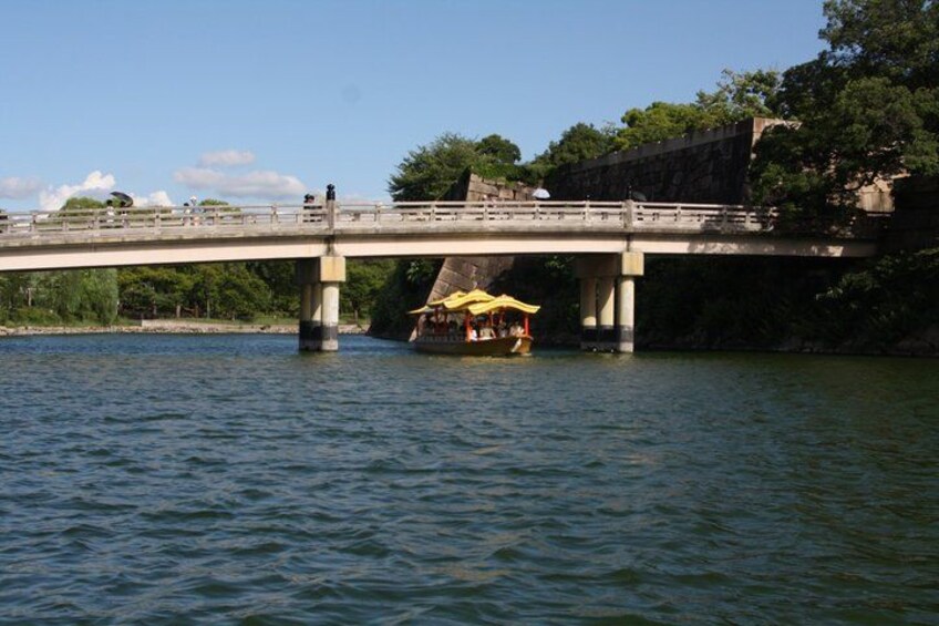 Eine Brücke über dem Wasser, mit einem Boot und einem gelben Regenschirm. 3