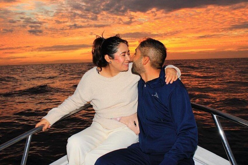 Una pareja en un barco, con un atardecer de fondo. 2