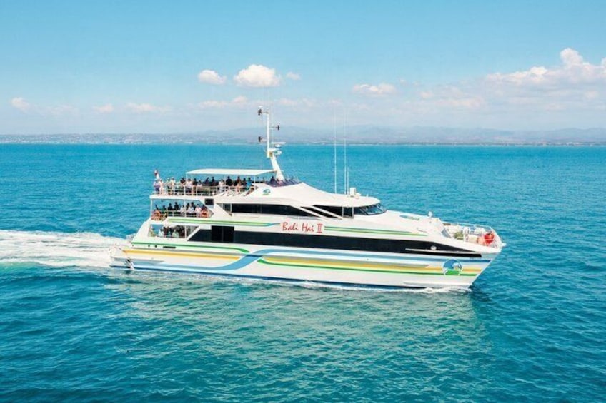 Un yate blanco grande con franjas azules y verdes navegando sobre aguas azules y cristalinas. 3