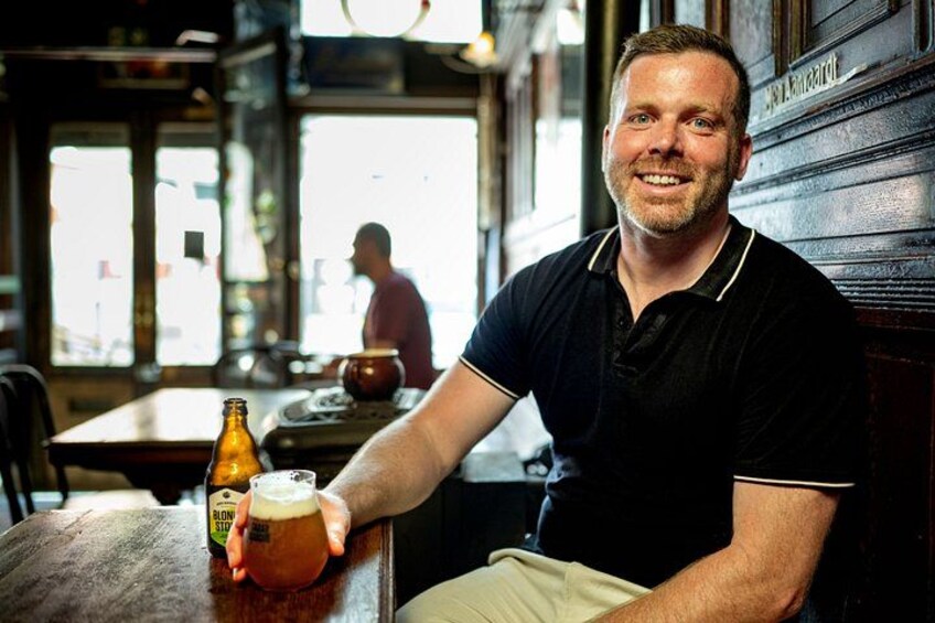 A person sitting at a table with a beer bottle and glass. 5