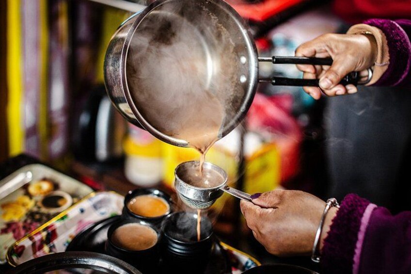 A person pouring a hot liquid from a pot into a metal container. 4