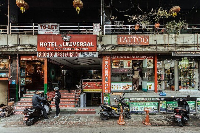 A building with signs for a hotel, a tattoo shop, and a bakery cafe. 2