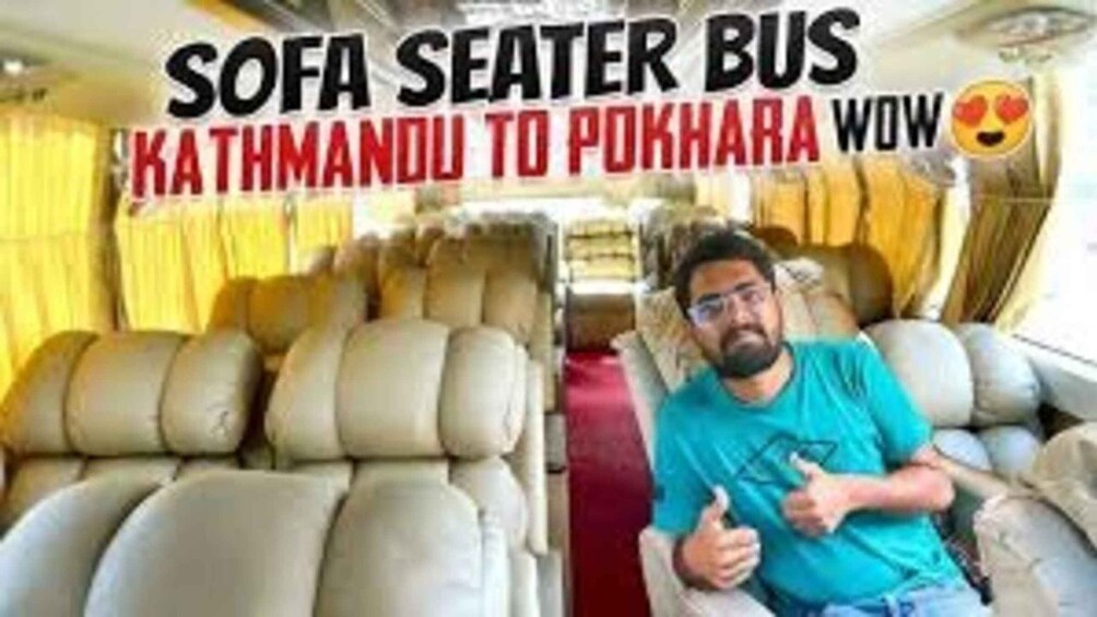 A bus interior with sofa seats and a person seated. 3