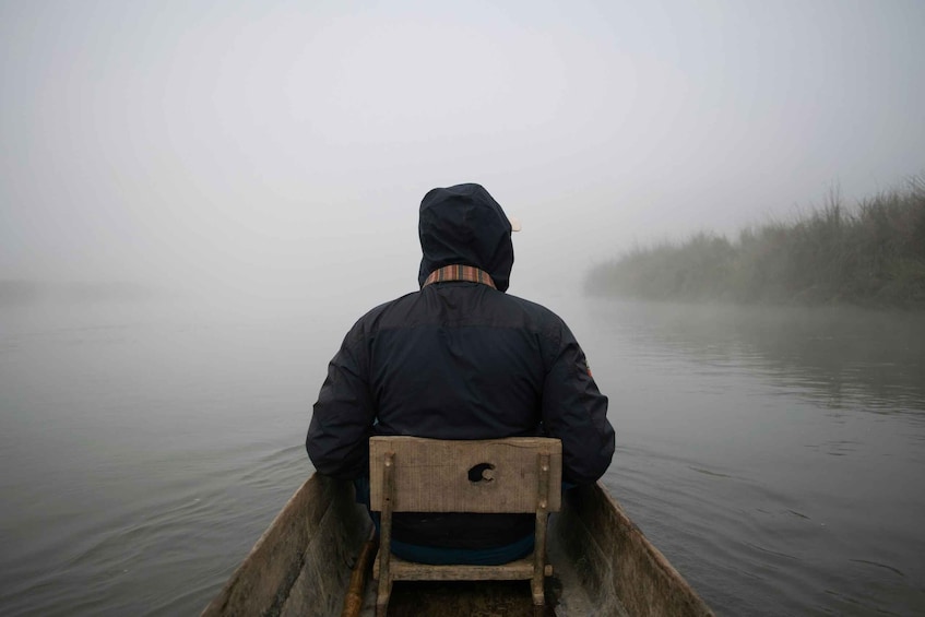 A person in a canoe on a foggy lake. 5