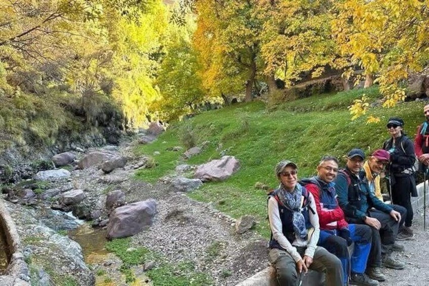 A group of hikers sitting by a stream in a forested area. 4
