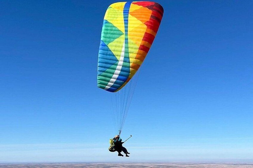 En person paraglider med et farverigt faldskærm. 1