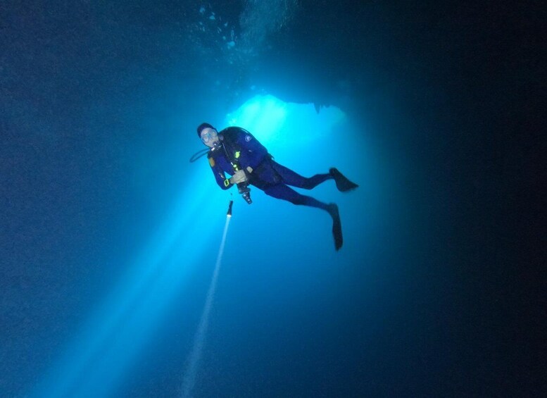 A diver underwater with a light source. 1