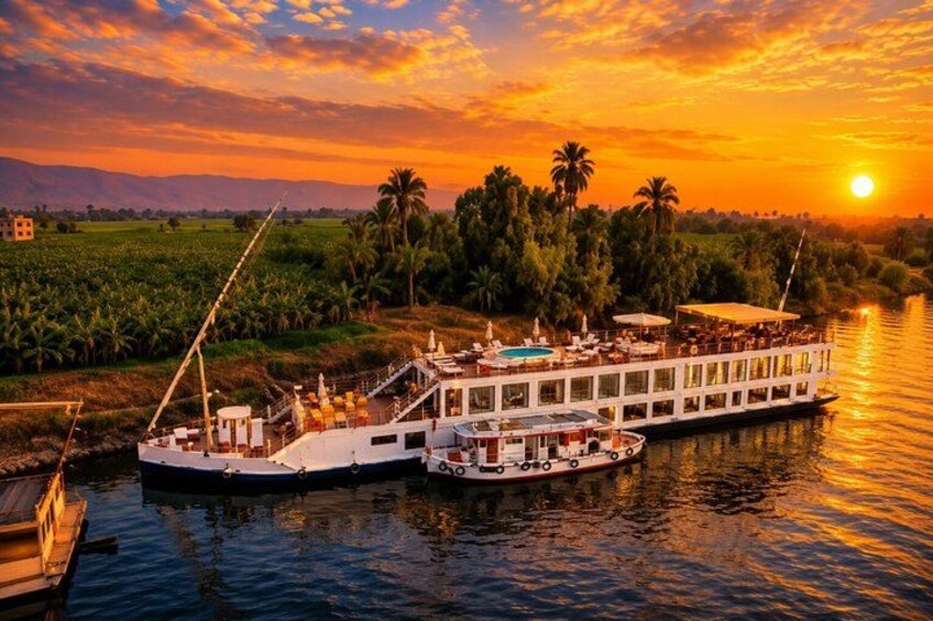 Una nave fluviale ormeggiata al tramonto con un paesaggio rigoglioso sullo sfondo. 1