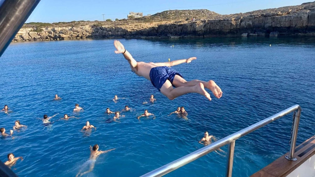 A person diving into a body of water surrounded by swimmers. 3