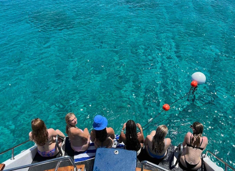 A group of people on a boat, looking at a buoy in the water. 4