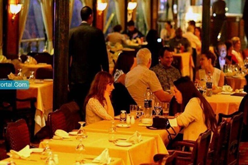 A restaurant with diners seated at tables, some with drinks and menus. 3