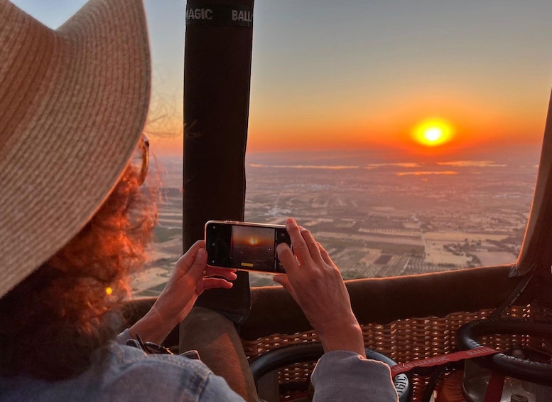 A person taking a photo of a sunset from a vehicle. 2
