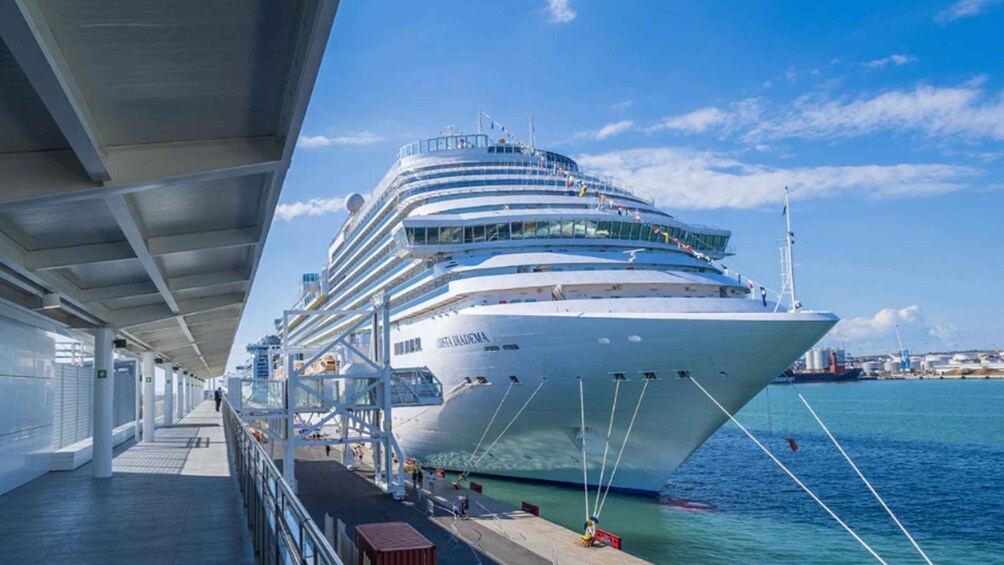 A large cruise ship docked at a port with a clear sky. 1