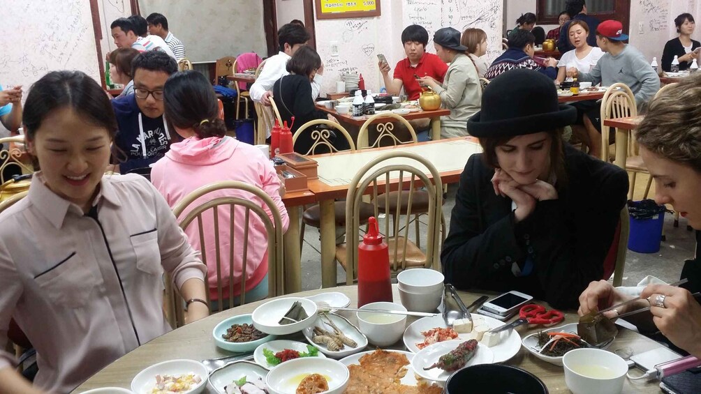 A group of people dining at a restaurant with various dishes on the table. 5