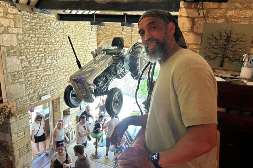 A man standing in a room with a car suspended in the air. 4