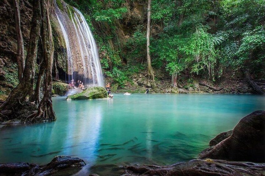 A waterfall, clear turquoise water, and lush greenery. 1