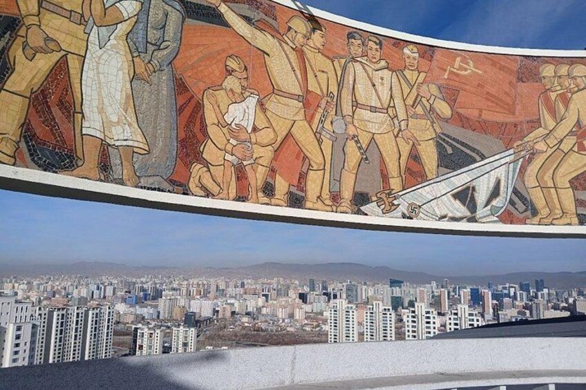 A cityscape with a mural depicting figures in uniform, a body of water, and high-rise buildings. 2