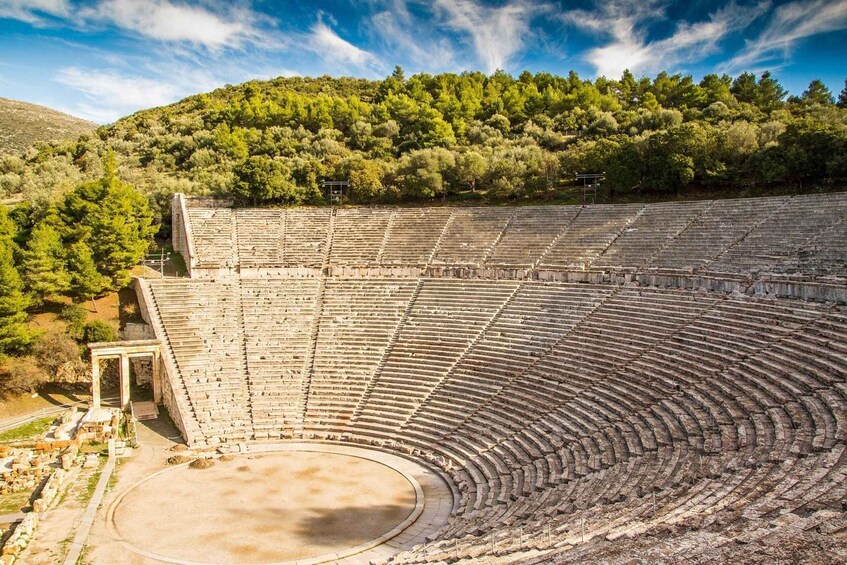An ancient amphitheater surrounded by forested hills. 3