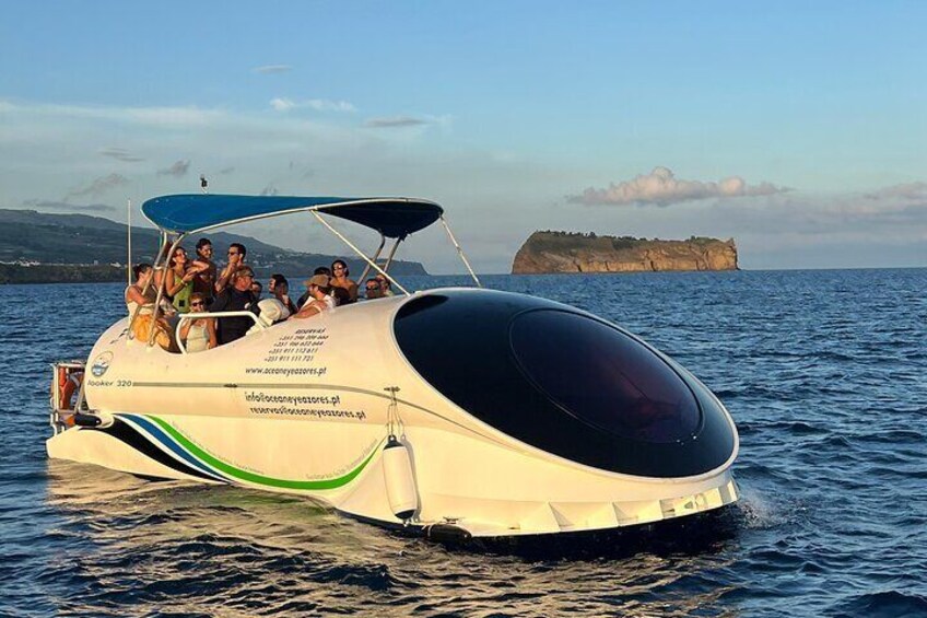 A boat with people on board, a rocky island in the background, and calm water. 4