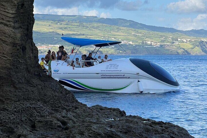 A boat with people on it near a rocky coastline. 3