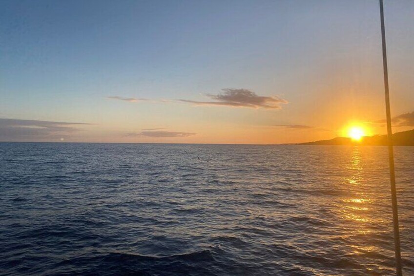 A sunset over the ocean with calm waters and a clear sky. 2