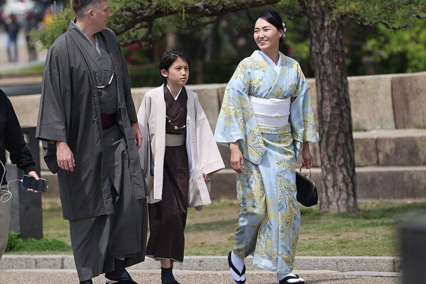 Una persona vestida con traje tradicional japonés caminando con otra persona. 4