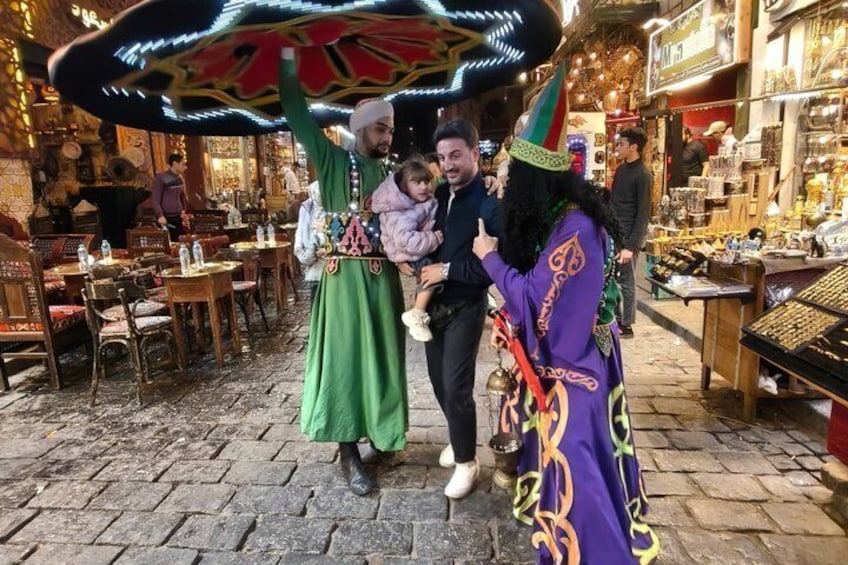 A cobblestone street with people in colorful costumes, a market stall, and a festive atmosphere. 5