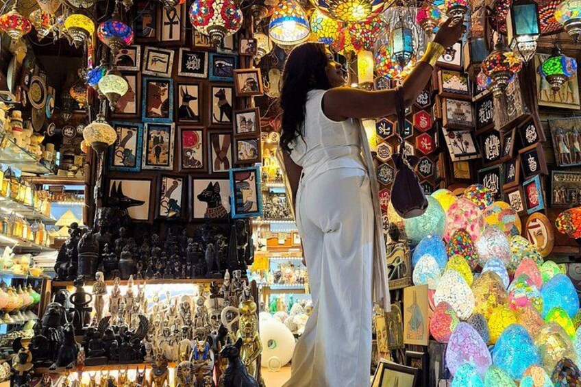 A person browsing a shop filled with various items, including framed pictures and decorative lights. 1