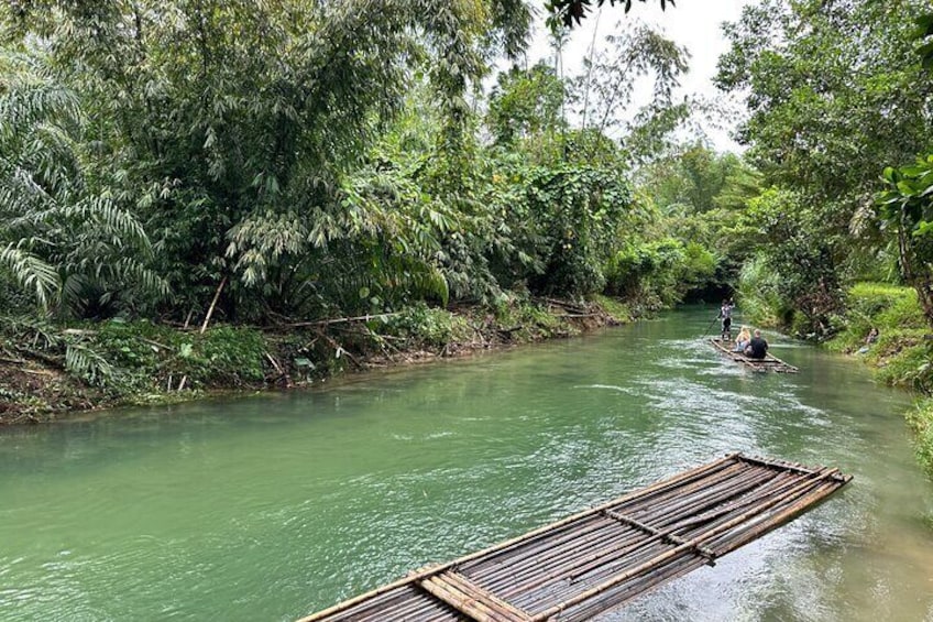 Een rivier met een houten vlot en iemand die peddelt. 1