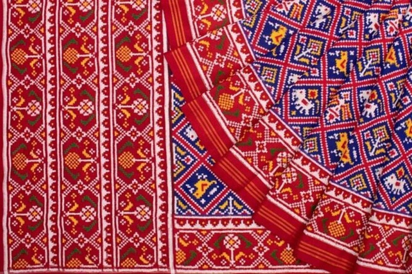 A textile with intricate geometric and floral patterns in red, blue, and yellow. 5