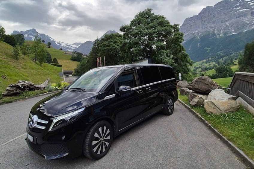 A black SUV parked on a road with a mountainous landscape in the background. 2
