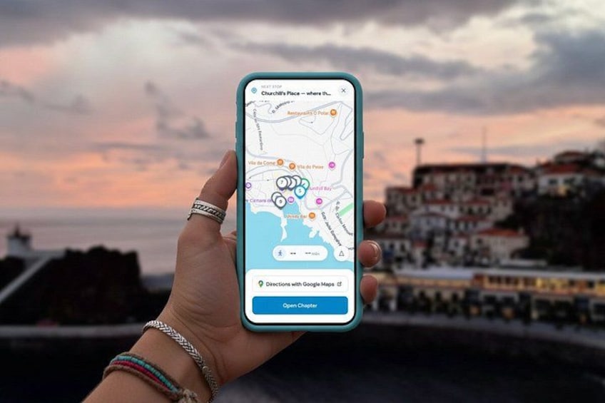 A hand holding a smartphone with a map application open, displaying a coastal cityscape with buildings and a sunset in the background. 5
