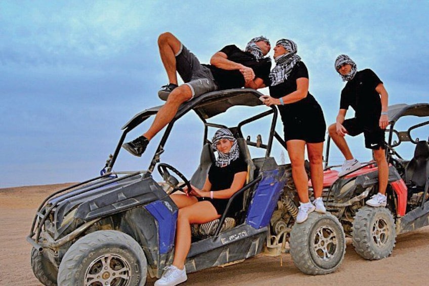 En gruppe mennesker i en dune buggy i et ørkenlandskab. 4