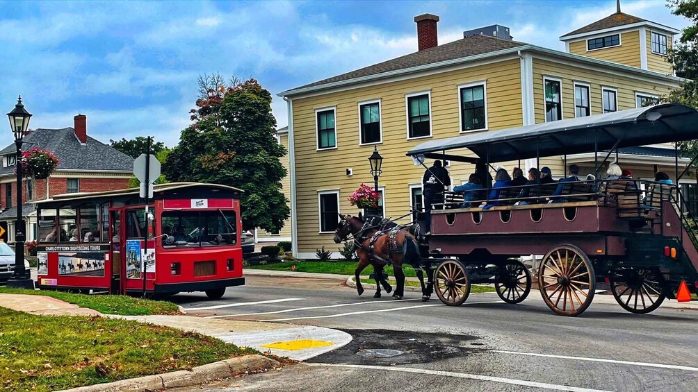 A red trolley and a horse-drawn carriage on a street. 4