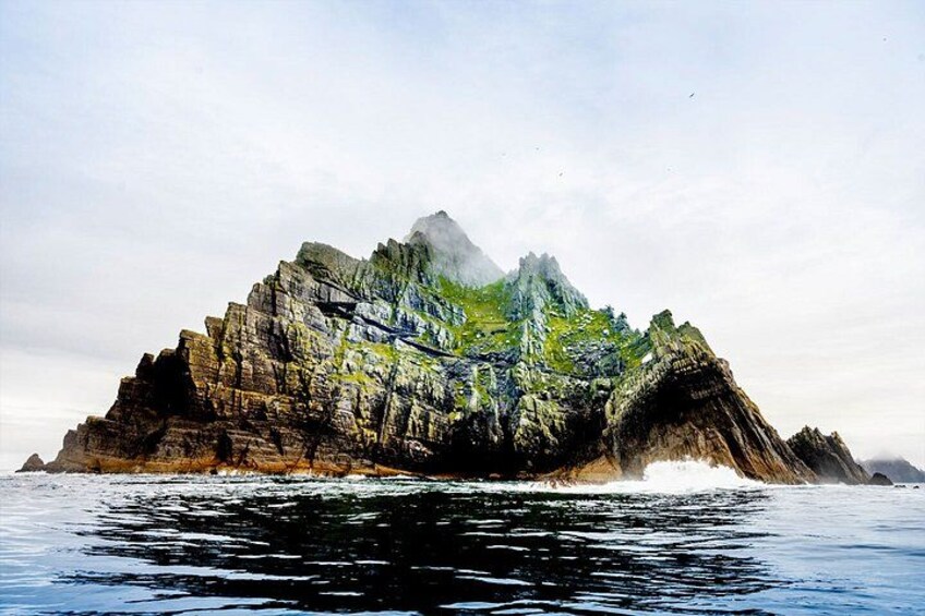 A rocky island with a rugged coastline and a clear sky. 2