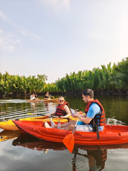 People kayaking on a calm river surrounded by lush greenery. 5