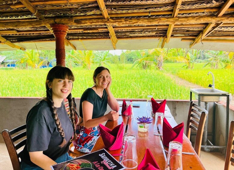 Two people dining at a table with a view of a lush green field. 5