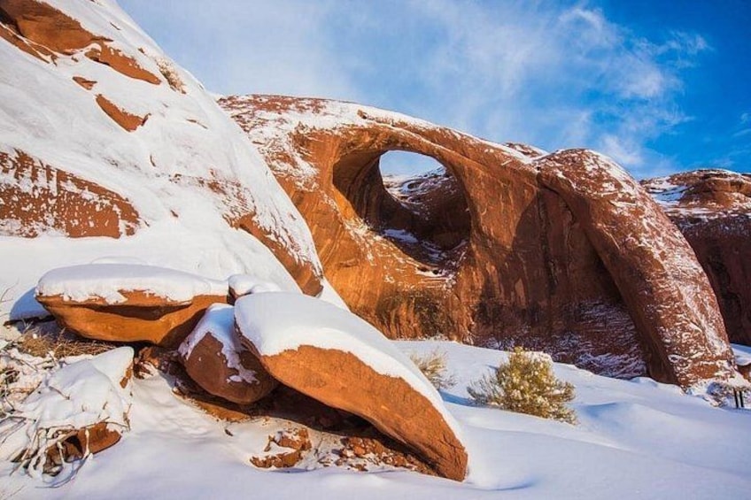 A snow-covered rock formation with a natural arch. 2