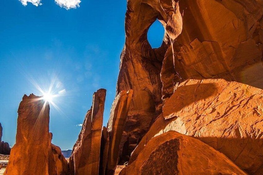 A rock formation with a clear sky and sunlight. 3