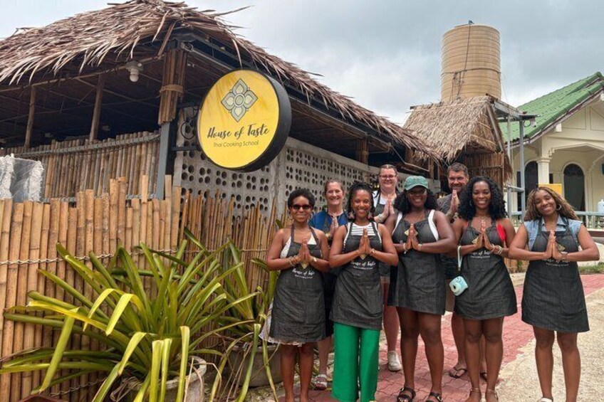 A group of people in front of a building with a sign that reads 'House of Taste.' 2