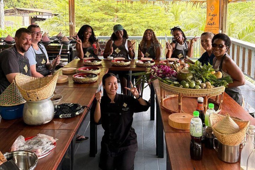 A group of people preparing food outdoors with cooking utensils and ingredients on a wooden table. 5