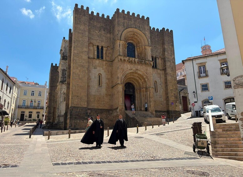 A historic stone building with a large arched entrance and a clock tower. 3