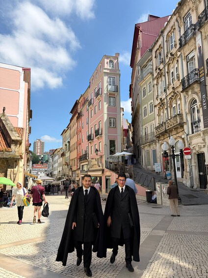 A cobblestone street lined with historic buildings, a clear blue sky, and pedestrians. 2