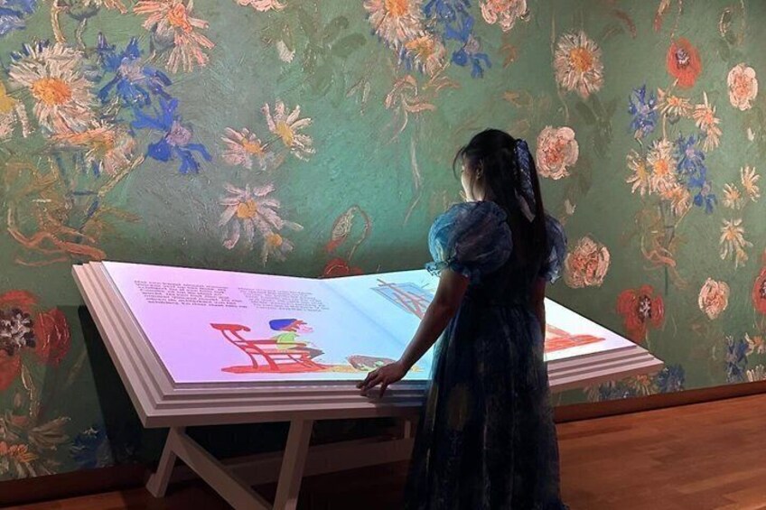 A person standing at a table with a large digital display. 3