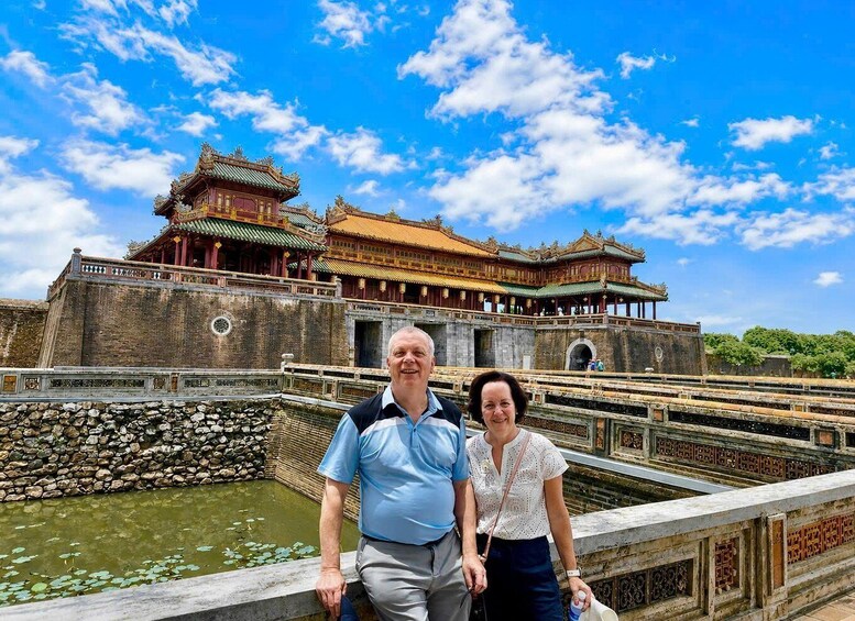A historic building with traditional architecture, a stone wall, and a water feature with lily pads. 1