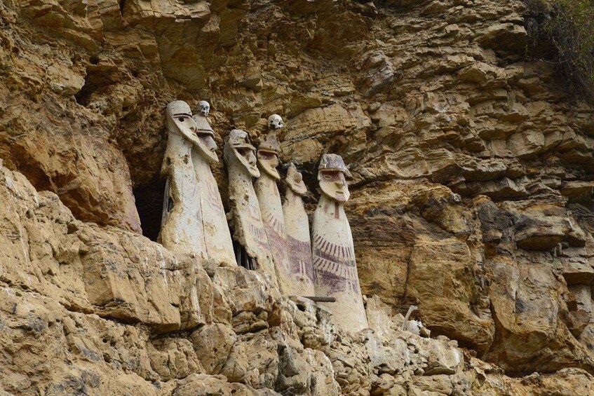 A series of carved figures in a rocky cliff face. 2
