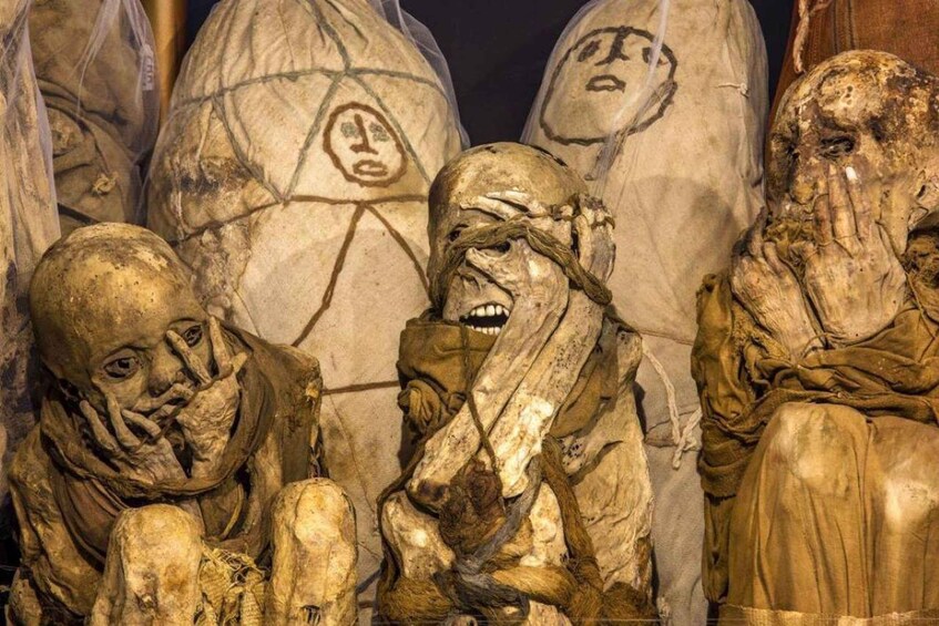 A sculpture of figures with faces covered in dirt, suggesting decay or age. 5