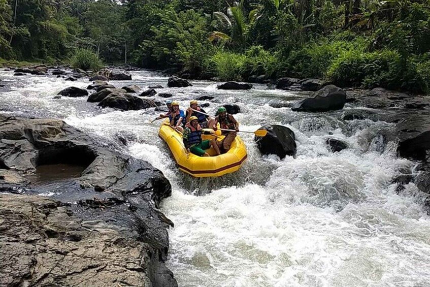 A group of people rafting down a river with rapids, surrounded by rocks and greenery. 1