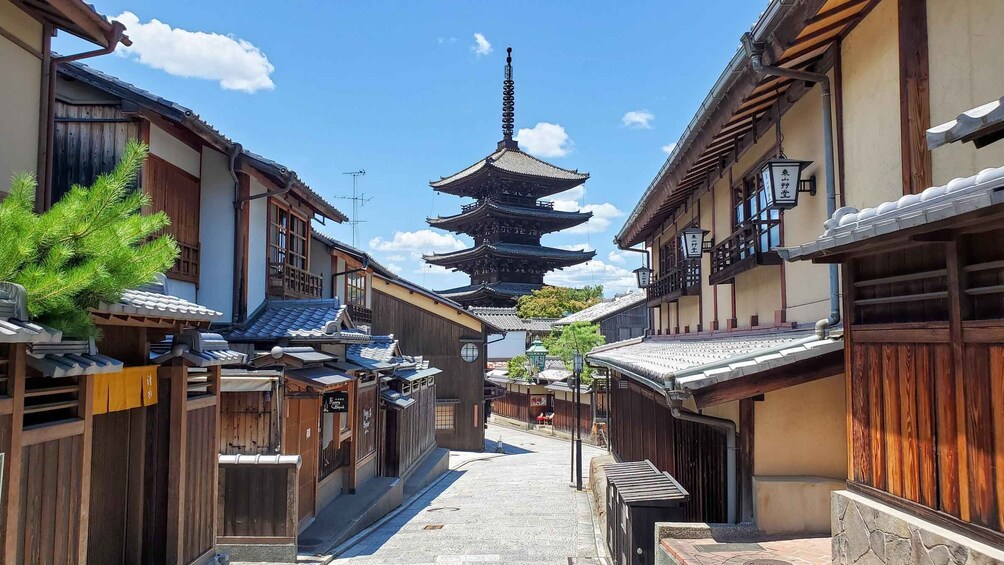 A traditional Japanese street with wooden buildings and a pagoda in the distance. 1
